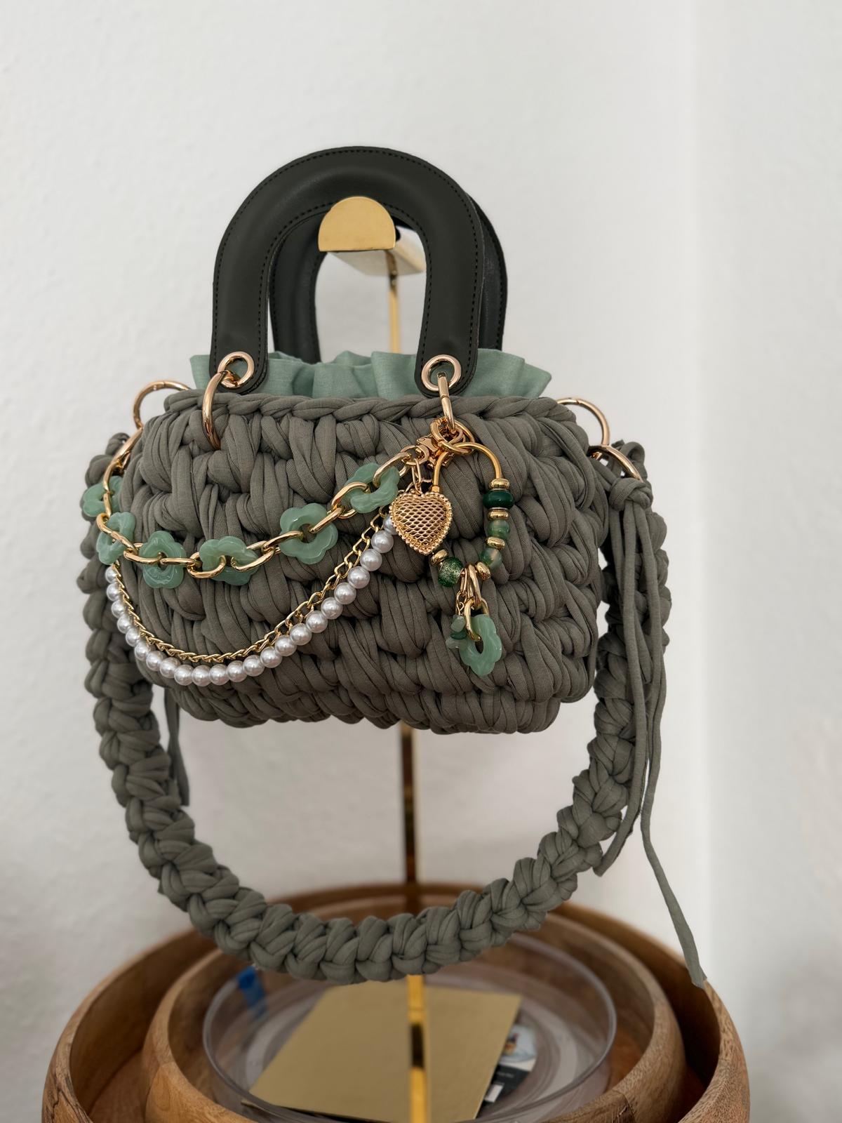 Salbeigrüne Duduhook Tasche mit schwarzem Henkel und goldenen Charms